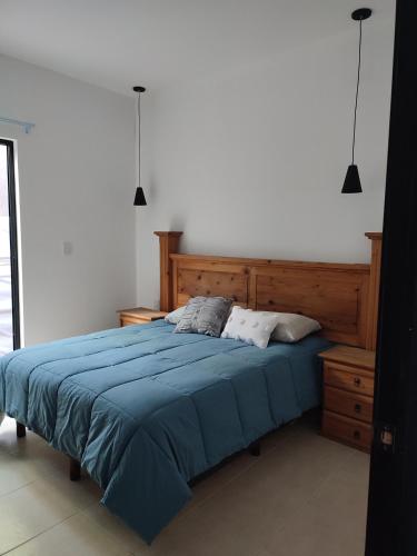 a bedroom with a bed with a blue blanket at LOMAS AEROPUERTO in San Agustin de las Juntas