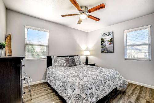 een slaapkamer met een bed en een plafondventilator bij Pecan Row Getaway in New Braunfels