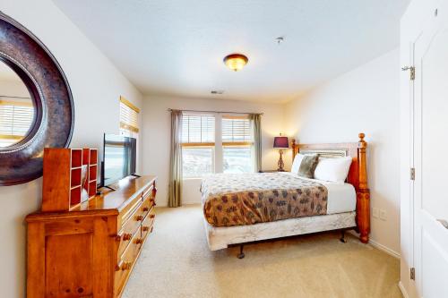 ein Schlafzimmer mit einem Bett, einer Kommode und einem Fernseher in der Unterkunft Fox Bay Escape in Heber City