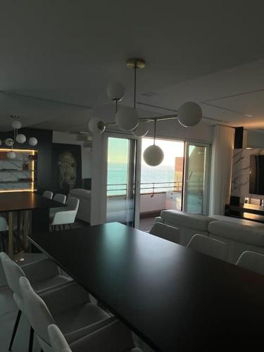 een eetkamer met een tafel en witte stoelen bij MH by MGM - Premium Sea Views in Porto
