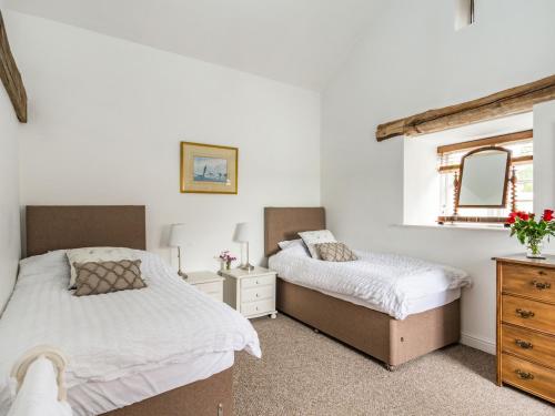 1 Schlafzimmer mit 2 Betten, einer Kommode und einem Spiegel in der Unterkunft Brook Cottage in Stearsby