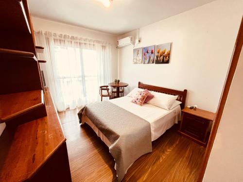 Dormitorio pequeño con cama y mesa en Casa da Praia Pousada - Guesthouse, en Torres