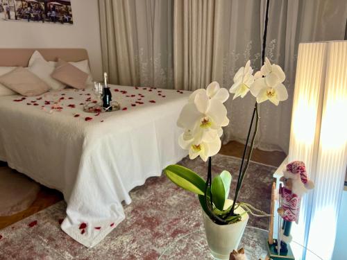 Un dormitorio con una cama con flores blancas. en Louis & Elza Old Town Romantic apartments, en Wroclaw
