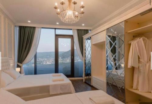 a bedroom with a white bed and a large window at apartment tbilisi 5 star king david residence in Tbilisi City