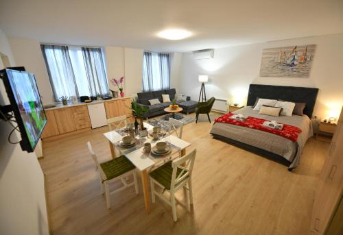 ein Wohnzimmer mit einem Bett und einem Esszimmer in der Unterkunft West in apartments in Čačak