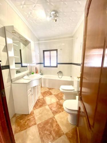 a bathroom with two toilets and a sink and a shower at Casa Cruz de Marbella Luque in Luque