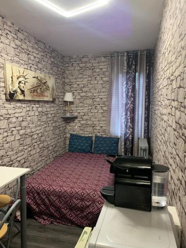 une chambre avec un lit et un mur de briques dans l'établissement Au Coeur De Lyon, à Lyon
