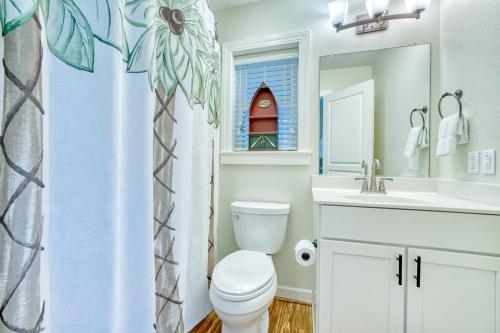 a bathroom with a toilet and a sink and a mirror at Gone Coastal 139 in Rodanthe
