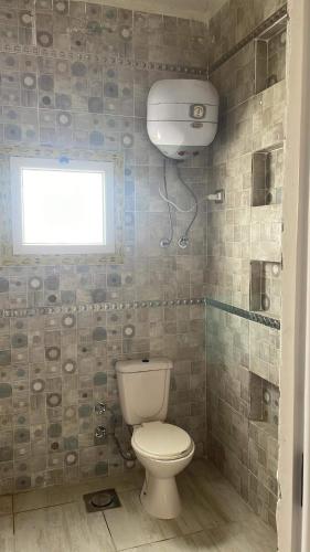 a bathroom with a toilet and a window at فيلا محمد بدر in Alexandria