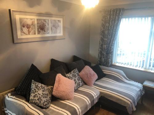 a living room with a couch with pillows on it at Moville Centre Apartment in Moville