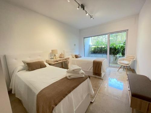 1 dormitorio con 2 camas y ventana en Live In Sotogrande en Sotogrande