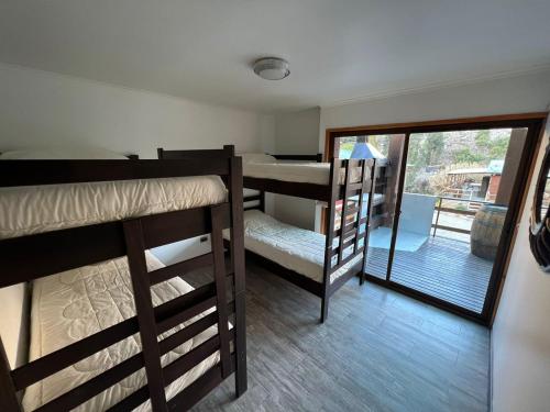 a room with two bunk beds and a balcony at OASIS DEL VALLE DEL ELQUI in La Serena