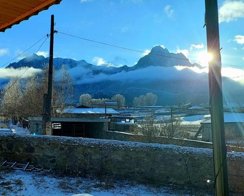 a view of a snowy mountain with the sun in the sky at Hotel Garbani in Stepantsminda
