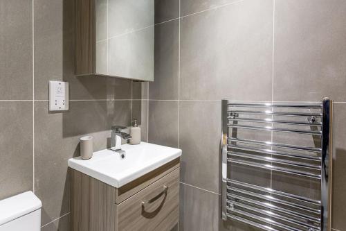a bathroom with a white sink and a shower at Stylish Duplex 5 min from centre in Newcastle upon Tyne