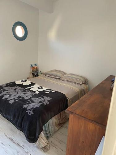 - une chambre avec un lit doté d'une couverture noire et d'une table en bois dans l'établissement Les Terrasses d'Alain F2 CV parking vélo, à Sète