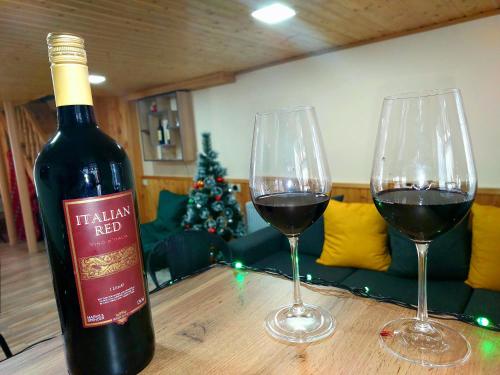 dos copas de vino tinto en una mesa de madera en Hotel Garbani, en Kazbegi