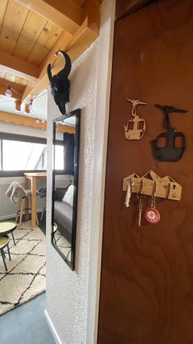 Un chat noir est assis sur un mur à côté d'un miroir dans l'établissement Les Menuires centre! Chaleureux studio sur les pistes!, aux Menuires