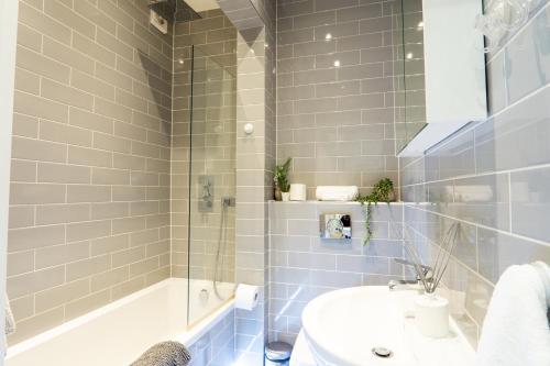 ein Badezimmer mit einem Waschbecken, einer Badewanne und einem WC in der Unterkunft A beautiful one bedroom flat with garden & parking in Mill Hill