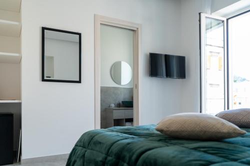 a bedroom with a bed and a tv on the wall at Alloggio nuovissimo al centro e rilassante in Ischia