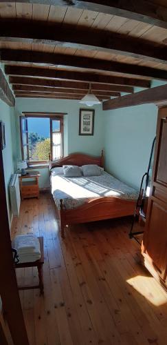 ein Schlafzimmer mit einem großen Bett und einem großen Fenster in der Unterkunft Nuestra casa de Luriezo in Cabezón de Liébana