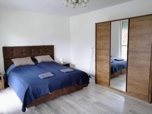 ein Schlafzimmer mit einem Bett und einem großen Spiegel in der Unterkunft Levendula Apartman Bükkszentkereszt in Bükkszentkereszt