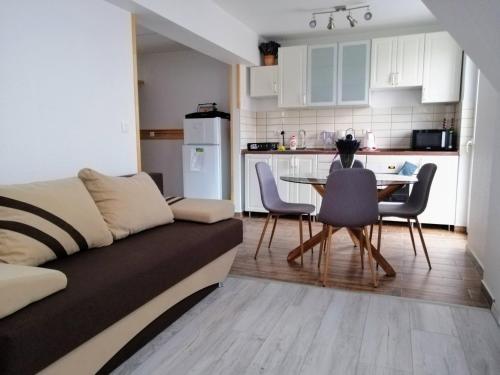 ein Wohnzimmer mit einem Sofa und einem Tisch mit Stühlen in der Unterkunft Levendula Apartman Bükkszentkereszt in Bükkszentkereszt