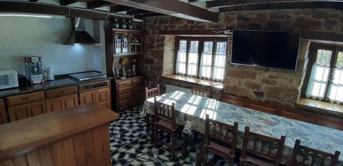 uma cozinha com mesa e cadeiras e uma televisão em Nuestra casa de Luriezo em Cabezón de Liébana