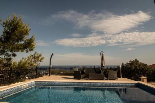 una piscina con sillas y vistas al océano en Villa magic en Rukavac