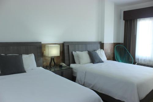 a hotel room with two beds and a window at Beverly Hills: Hotel and Business in San Salvador