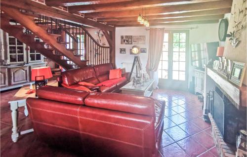 - un salon avec un canapé en cuir rouge et des escaliers dans l'établissement Beautiful Home In Salbris, à Salbris