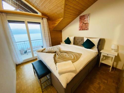 a bedroom with a large bed with a large window at Lake View Apartment -14 in Niederried