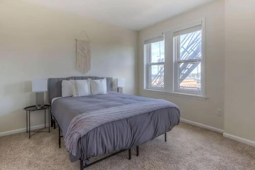 a bed in a white room with a window at Perfect 1BR In Prime Location & View of Stadiums in Detroit