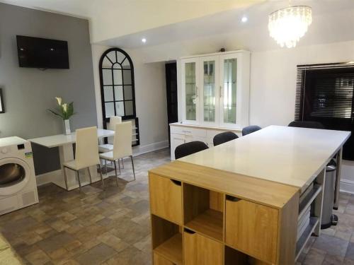 cocina y sala de estar con mesa y sillas en Beautiful Family Apartment Available Central Wigan I Free Parking I Sleeps 6 I, en Wigan