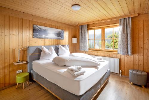 ein Schlafzimmer mit einem großen Bett in einem Holzzimmer in der Unterkunft Apartmenthaus Matri in Wald am Arlberg