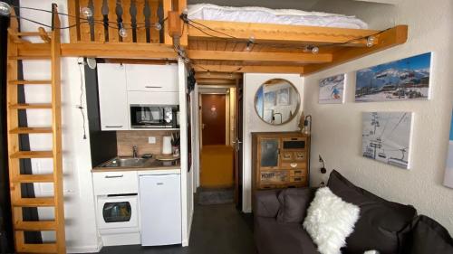 a tiny house with a kitchen and a loft bed at Les Menuires centre! Chaleureux studio sur les pistes! in Les Menuires