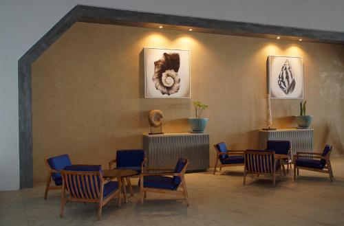 a waiting room with chairs and tables and pictures on the wall at Royal Villas Resort in Mazatlán