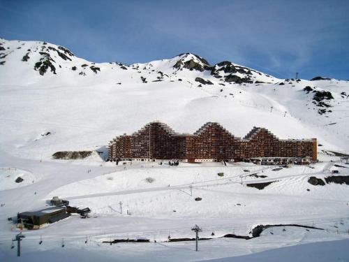 un bâtiment au sommet d'une montagne enneigée dans l'établissement T2 Cosy au pied des pistes, à Bagnères-de-Bigorre