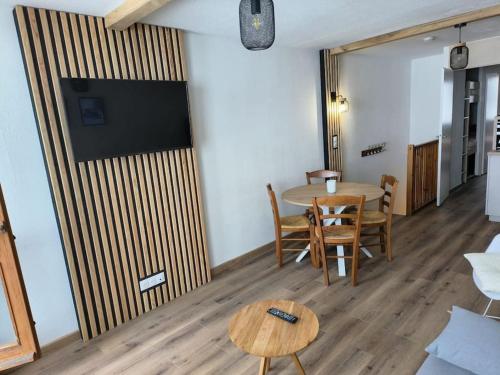 une pièce avec une table, des chaises et une télévision dans l'établissement T2 Cosy au pied des pistes, à Bagnères-de-Bigorre