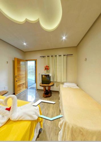 a room with two beds and a tv in it at Pousada Rekantu do Poeta in Alter do Chao