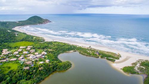 an aerial view of a beach and the ocean at Pousada Flor de Lotus in Praia do Rosa