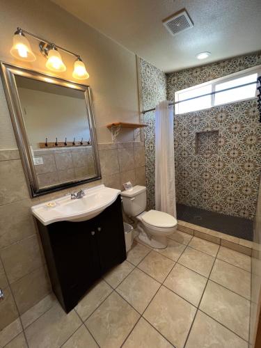 a bathroom with a sink and a toilet and a mirror at Seven Bluff Cabins in Concan