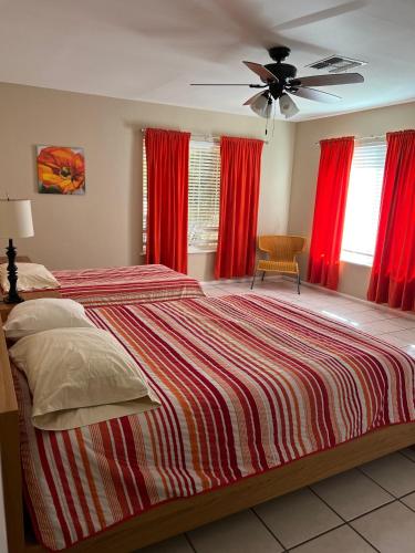 a bedroom with a large bed with red curtains at Seven Bluff Cabins in Concan
