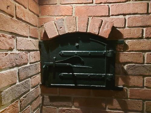 a green mailbox on a brick wall at Romantic Lakeside Cottage by the Beach! with Super Cosy Log Burner! The Perfect Escape to Your Home from Home by the Sea! So Relaxing - You Won't want to Leave! Pet Friendly! in Mablethorpe