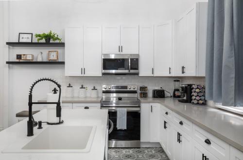 a white kitchen with a sink and a microwave at Beautifully updated New Orleans home in New Orleans