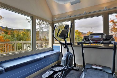 a room with a treadmill and windows with a view at Fall Line Condos by Killington VR - Studios in Killington