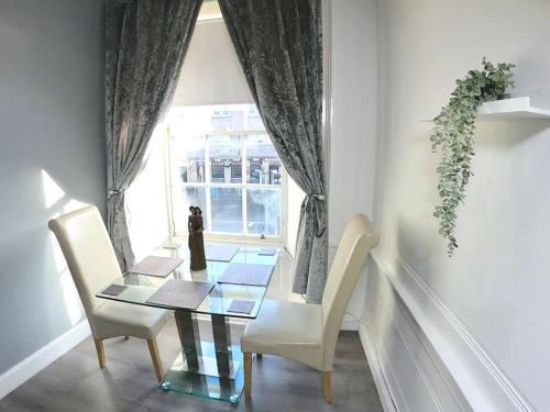 une salle à manger avec une table en verre et deux chaises dans l'établissement Fantastic - Centrally located 1 bed APT with Wi-fi, à Dalkeith