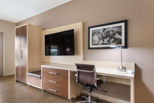 a office with a desk and a chair and a tv at Best Western Bandera Suites & Saloon in Bandera