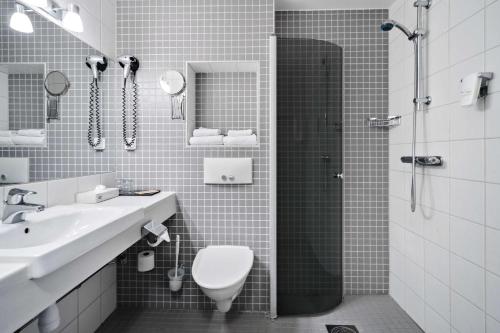 La salle de bains est pourvue d'une douche, de toilettes et d'un lavabo. dans l'établissement Best Western Hotel Vidöstern, à Värnamo