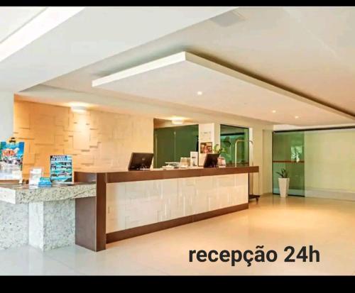 a lobby with a reception desk in a building at Flat Tabatinga Nord, vista para o mar in Conde