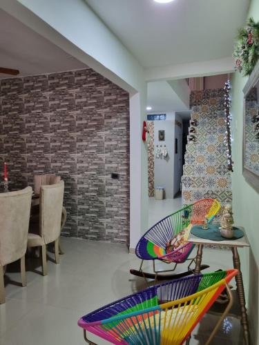 Habitación con sillas, mesa y pared de ladrillo en Casa Rebecca 39-41, en Cartagena de Indias